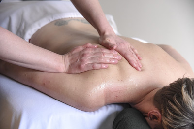 A prson getting a shoulder and back massage for stress relief at Threepoint Massage & Yoga Therapy in Millarville, AB